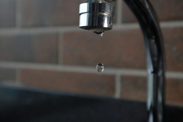 Hand pulling a faucet cartridge out of a kitchen faucet body